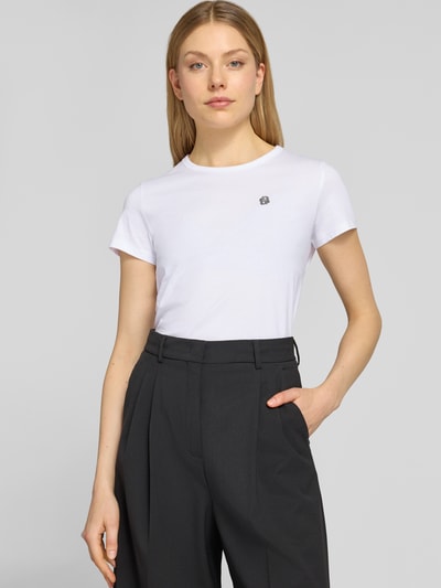 Frauenmodel trägt Regular Fit T-Shirt aus reiner Baumwolle Modell 'Eventsa11' von BOSS in Weiß, Jersey-Stoff, unifarben, Rundhals, Label Stitching, Nahaufnahme Oberkörper.