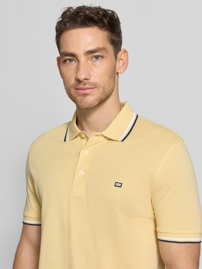 Männermodel trägt Regular Fit Poloshirt mit Kontraststreifen von Christian Berg Men aus reiner Baumwolle, Nahaufnahme Oberkörper.