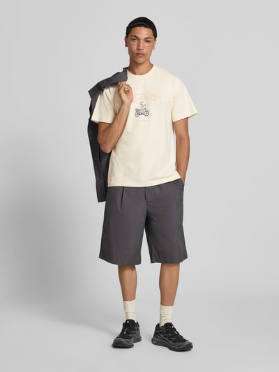 Männermodel trägt Regular Fit T-Shirt mit Motiv-Print von Forét aus Reine Baumwolle, Logo-Print, Rundhalsausschnitt, Rückenlänge 67 cm, Ganzkörperansicht von vorne.
