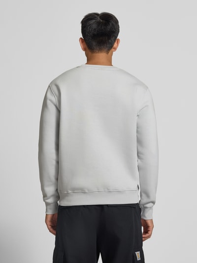 Männermodel trägt Regular Fit Sweatshirt aus Baumwoll-Mix mit Label-Detail von Alpha Industries, hellgrau, elastische Abschlüsse, Ganzkörperansicht Rückansicht.