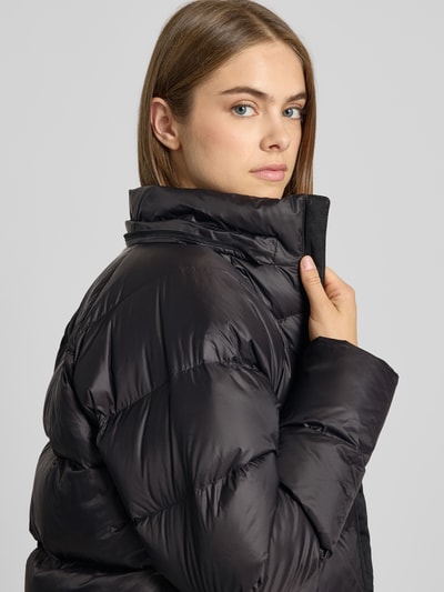 Frauenmodel trägt Steppjacke mit Label-Stitching Modell 'HYDRENALITE CITY DOWN' von The North Face in Schwarz, Nahaufnahme Oberkörper. Damen Steppjacke, Mix mit Stretch-Anteil, Regular Fit, Kapuze, Reißverschluss, Rückenlänge 60 cm, Schulterbreite 55 cm, Brustweite 48 cm, Ärmellänge 57 cm.
