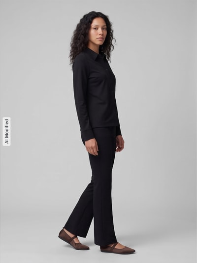 Frauenmodel trägt Relaxed Fit Langarmbluse aus Baumwoll-Mix von s.Oliver RED LABEL in Schwarz, glatte Struktur, Ganzkörperansicht von vorne, KI-modifiziertes Bild.