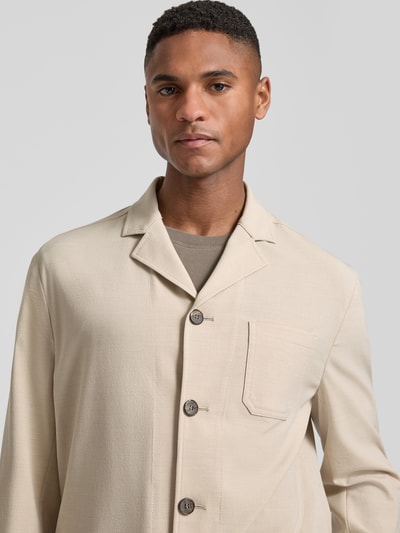 Männermodel trägt Relaxed Fit Hemdjacke mit Viskose-Anteil Modell 'Bill' von DIGEL, Beige, strukturierte Oberfläche, Nahaufnahme Oberkörper. Elastischer Material-Mix, aufgesetzte Tasche, Reverskragen, durchgehende Knopfleiste, Rückenlänge 75 cm bei Größe 50.