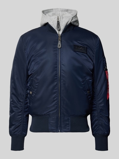 Produktfoto, Bomberjacke mit Kapuze und Label-Details von Alpha Industries, dunkelblau mit Reißverschluss, Eingrifftaschen, strukturierte Bündchen, Regular Fit, Kapuze in Grau, detailreiche Textur und sichtbare Label-Elemente, Herrenmodell gemäß Größenangaben.