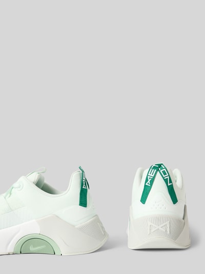 Produktfoto, Sneaker mit Logo-Detail Modell 'Metcon' von Nike in Weiß mit grünen Akzenten, abgerundete Passform, Damen, Schnürverschluss, Absatzhöhe 6 cm, Schafthöhe 7 cm, Schaftweite 6 cm, glatte und strukturierte Texturen