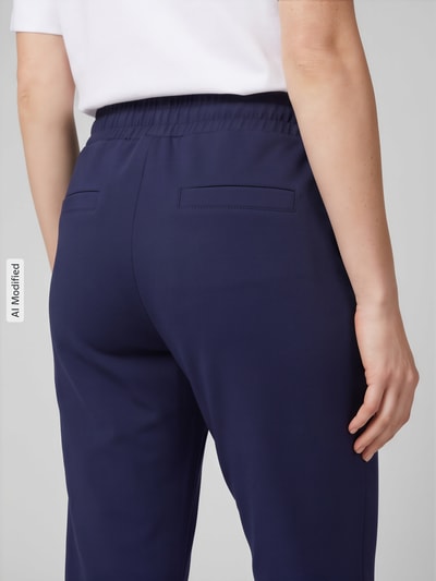 Frauenmodel trägt Sweatpants mit Paspeltaschen am Gesäß von Christian Berg Woman, unifarbenes Design, Nahaufnahme Rückansicht, KI-modifiziertes Bild.