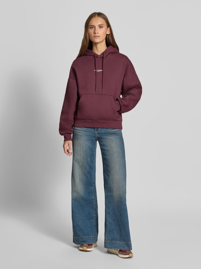 Frauenmodel trägt Relaxed Fit Hoodie aus Baumwoll-Mix Modell 'VESTERBRO' von JJXX, Känguru-Tasche, Label-Detail, Ganzkörperansicht von vorne.