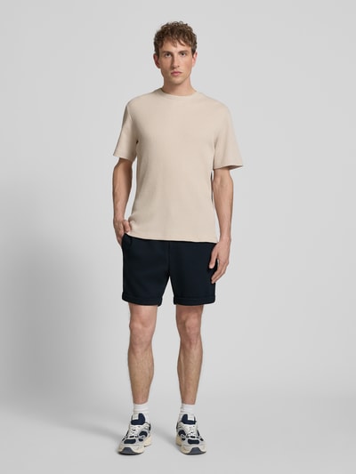 Männermodel trägt Regular Fit Shorts mit Viskose-Anteil Modell 'NEWKODYL' von Only & Sons, Melange-Optik, Nadelstreifen-Muster, Ganzkörperansicht von vorne.