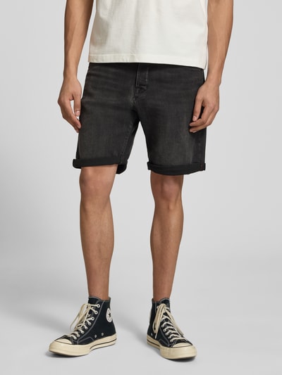 Männermodel trägt schwarze Jeansshorts mit Umschlag Modell 'RICK' von Jack & Jones, Baumwoll-Mix mit Stretch-Anteil, Regular-Fit, Ganzkörperansicht von vorne.