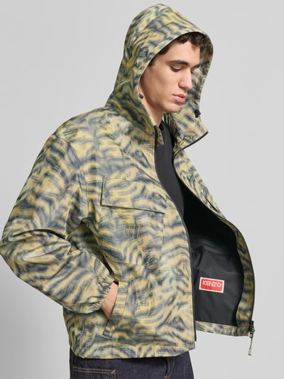 Männermodel trägt Regular Fit Windbreaker mit Kapuze von Kenzo, Allover-Animal-Print, Brusttaschen, Reißverschluss, Nahaufnahme Oberkörper.