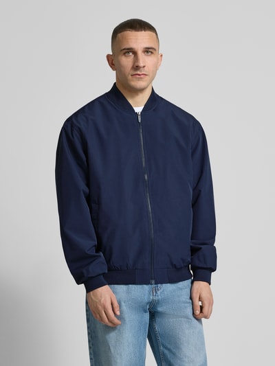 Männermodel trägt dunkelblaue Bomberjacke mit Stehkragen Modell 'CHARGE' von Jack & Jones, Regular-Fit, Reißverschluss, Ganzkörperansicht von vorne, Rückenlänge 67 cm, Schulterbreite 53 cm, Brustweite 62 cm, Ärmellänge 65 cm