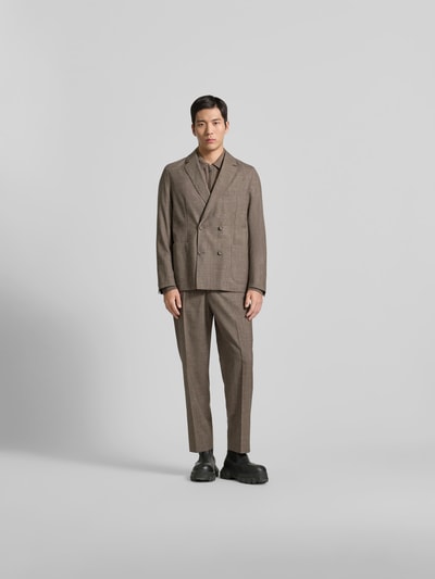 Männermodel trägt Anzughose aus Viskose-Mix von Officine Générale in Braun mit Bügelfalte, Straight Fit, integriertem Gürtel, Ganzkörperansicht von vorne.