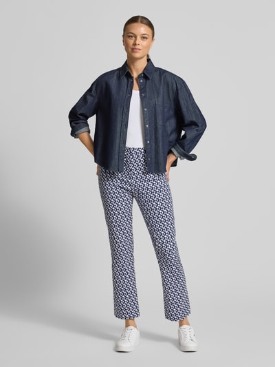 Vrouwenmodel draagt Stoffhose met geometrische allover-print Modell 'Maika' van Raffaello Rossi in blauw-wit, flared fit, volledige lichaamsvoorzijde. Elastische katoenmix, haak- en ritssluiting, strak patroon.