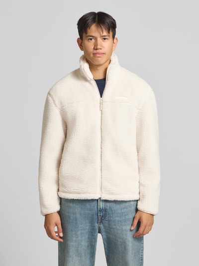 Männermodel trägt Fleecejacke mit Label-Detail und Reißverschluss von REVIEW in Teddyfell, Stehkragen, cremefarben, Ganzkörperansicht von vorne.