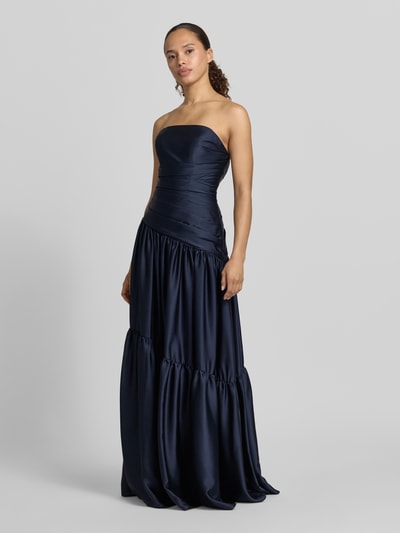 Frauenmodel trägt Abendkleid im Stufen-Look von Luxuar in Dunkelblau, Taillierte Passform, Maxikleid, Ärmelloses-Design, glänzende glatte Textur, Reißverschluss auf der Rückseite, Rückenlänge 125 cm, Brustweite 34 cm, Ganzkörperansicht von vorne.