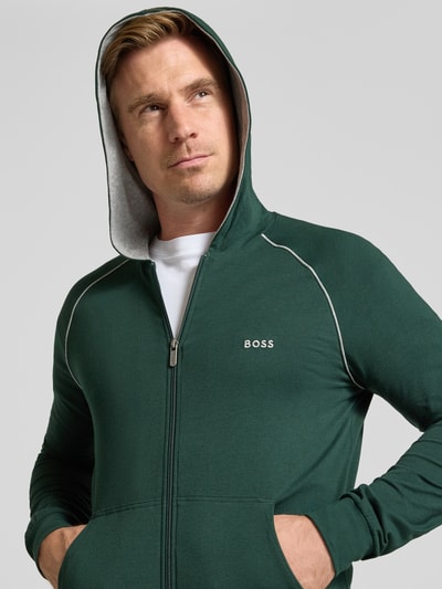 Männermodel trägt Regular Fit Sweatjacke aus Baumwoll-Mix Modell 'Mix&Match Jacket H' von BOSS in Dunkelgrün mit weißen Details, Nahaufnahme Oberkörper, Herren Sweatjacke von BOSS.