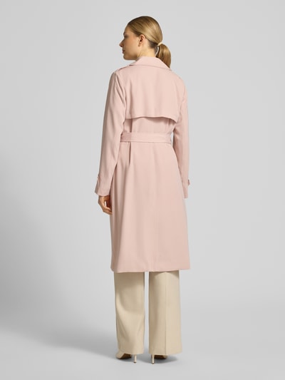 Vrouwenmodel draagt 'Zweireihiger Trenchcoat mit Bindegürtel' van MICHAEL Michael Kors in lichtroze, regular fit, reverskraag, rugaanzicht.