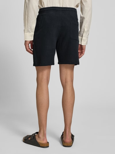 Männermodel trägt schwarze Herren Shorts mit Strukturmuster Modell 'AIDEN' von Jack & Jones aus Material-Mix, Straight Fit, Ganzkörperansicht Rückansicht.