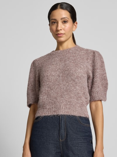 Kobiece model prezentuje sweter z dodatkiem wełny krój regular fit model 'NOVAH' od VERO MODA w kolorze jasnofioletowym, miękka tekstura, zbliżenie na górną część ciała
