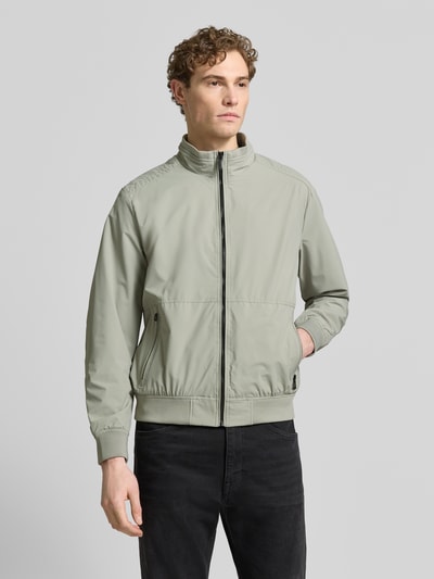 Männermodel trägt Regular Fit Jacke mit Stehkragen von Lerros in hellem Grün, glatte Textur, Logo-Detail, Reißverschlüsse, Ganzkörperansicht von vorne.