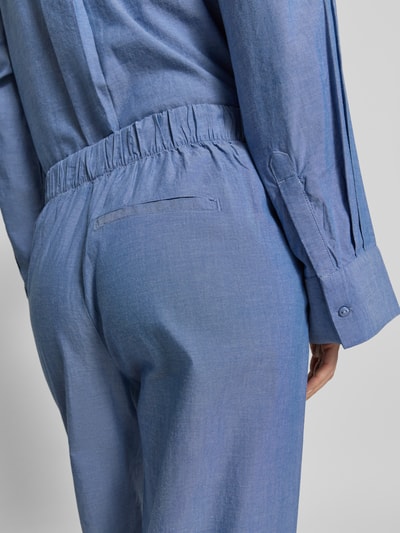 Kobiece modelka nosi Regular Fit Weite Hose aus reiner Baumwolle Modell 'KIRA-TARA' od Selected Femme, materiał popelina, melanż, elastyczny pas, boczne kieszenie, widok z tyłu, zbliżenie na dolną część pleców.