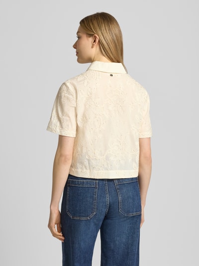 Männermodel trägt Regular Fit Bluse mit Stitchings und Pailletten von Liu Jo White, kremowy kolor, bawełna, kołnierzyk koszulowy, długość tyłu 48 cm, długość rękawów 23 cm, krój regular fit, hafty, cekiny, listwa guzikowa ukryta, widok całej sylwetki z tyłu.