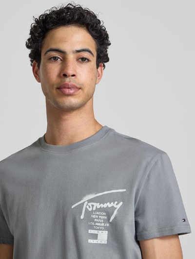 Männermodel trägt Regular Fit T-Shirt aus reiner Baumwolle von Tommy Jeans, Optik: Unifarben, Rundhals, Label-Schriftzug, Jersey, Nahaufnahme Oberkörper.