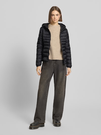 Modelka kobieca ma na sobie czarną Regular Fit Steppjacke mit Kapuze Modell 'TAHOE' od Only, nylon, jednolita, długość tyłu 59 cm, szerokość w rozmiarze S 47 cm, szerokość ramion 40 cm, długość rękawa 62 cm, przód pełny kadr całej sylwetki.