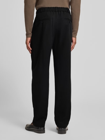 Männermodel trägt schwarze Regular Fit Hose mit Leinen-Anteil von Emporio Armani, Lyocell-Mix, lockere Passform, Ganzkörperansicht Rückansicht.