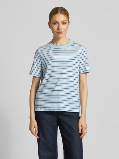Kobiece modelka nosi damski t-shirt Regular Fit T-Shirt aus reiner Baumwolle Modell 'PAULINA' von Vero Moda, efekt: wzór w paski, okrągły dekolt, krótki rękaw, dżersej z czystej bawełny, jasnoniebieski z cienkimi ciemniejszymi paskami, faktura miękka, Ganzkörperansicht von vorne.