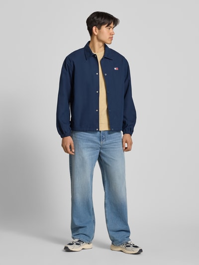 Männermodel trägt Regular Fit T-Shirt aus reiner Baumwolle von Tommy Jeans, unifarben, Rundhals, Slub Jersey, Ganzkörperansicht von vorne.