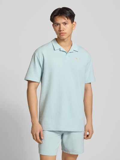 Männermodel trägt Regular Fit T-Shirt mit Logo-Stitching von PUMA PERFORMANCE aus Baumwoll-Mix mit Stretch-Anteil, Strukturmuster, Reverskragen, Ganzkörperansicht von vorne.