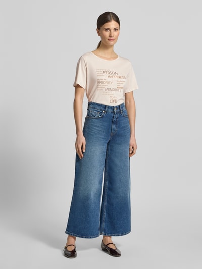 Frauenmodel trägt T-Shirt mit Strasssteinbesatz von monari in Hellbeige, Statement-Print, Baumwolle, gerader Schnitt, Ganzkörperansicht von vorne.