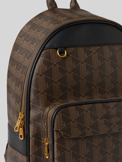 Produktfoto, Rucksack mit Logo-Prägung von Lacoste, braunes Muster, goldfarbener Reißverschluss, glatte und strukturierte Oberfläche, Herren Rucksack von Lacoste