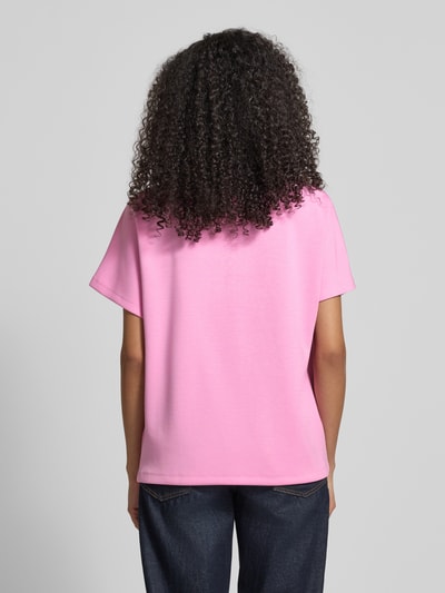 Frauenmodel trägt T-Shirt mit Rundhalsausschnitt und Perlen von Christian Berg Woman in Rosa, entspannter Schnitt, Rückansicht, Ganzkörperansicht.