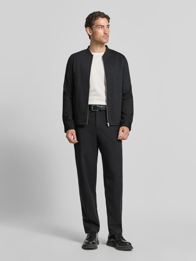 Męski model nosi Slim Fit Sweatjacke mit Stehkragen od Lindbergh, Mieszanka materiałów z dodatkiem streczu, stójka, zamek błyskawiczny, boczne wpuszczane kieszenie, długość tyłu w rozmiarze M: 67 cm, długość rękawów w rozmiarze M: 66 cm, ciemna kolorystyka, gładka tekstura, krój slim fit, Ganzkörperansicht z przodu.