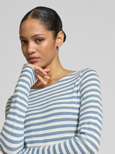 Frauenmodel trägt Regular Fit Langarmshirt aus reiner Baumwolle von Marc O'Polo mit blau-weißem Allover-Streifenmuster, Logo-Print, U-Boot-Ausschnitt, Nahaufnahme Oberkörper.