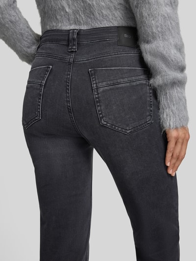 Frauenmodel trägt Bootcut Jeans mit Label-Patch Modell 'MARY' von Brax in Schwarz, 5-Pocket-Design, Baumwollmix, Detailaufnahme Rückansicht.