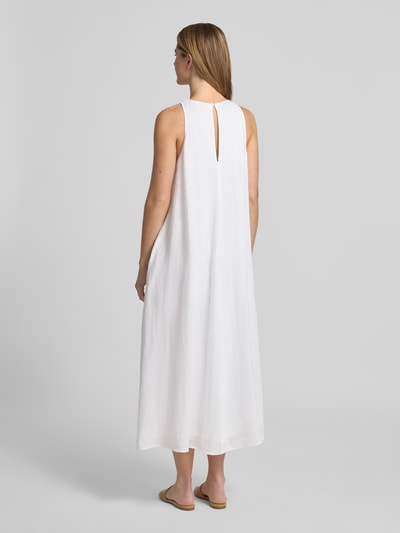 Frauenmodel trägt weißes Midikleid aus Leinen in A-Linie mit Rundhalsausschnitt, Modell 'UKARA' von ECOALF, Ganzkörperansicht Rückansicht. Reines Leinen, Rückenlänge 125 cm, Brustweite 65 cm, glatte Textur.