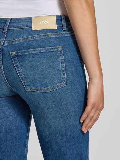 Frauenmodel trägt Flared Jeans mit Knopfverschluss Modell 'ROME' von JJXX, blauer Baumwoll-Mix mit Stretch, Nahaufnahme Rückansicht, 5-Pocket-Design.