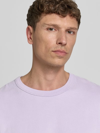 Männermodel trägt T-Shirt mit überschnittenen Schultern Modell 'FAZY' von American Vintage in Hellviolett, reine Baumwolle, Nahaufnahme Oberkörper.