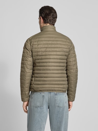 Männermodel trägt olivgrüne Steppjacke mit Zweiwegereißverschluss Modell 'Alexander' von SAVE THE DUCK, Ganzkörperansicht Rückansicht, Stepp-Optik, Regular Fit, gefütterter Stehkragen, glatte Textur, Eingrifftaschen mit Reißverschluss, Maße laut Kontext.