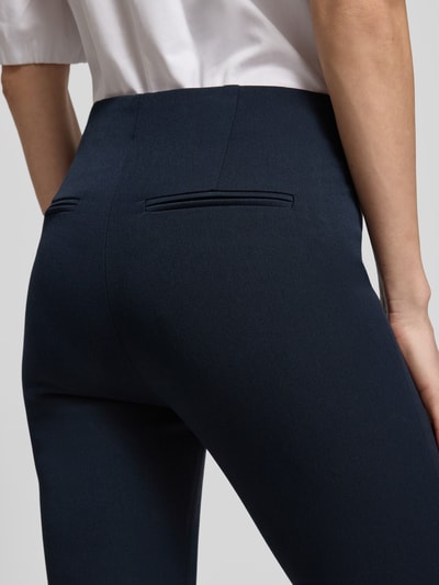 Frauenmodel trägt Caprihose mit Längsnähten von Rich & Royal in Dunkelblau, Viskose-Mix, Gesäßtaschen, Slim Fit, Detailaufnahme Rückansicht.