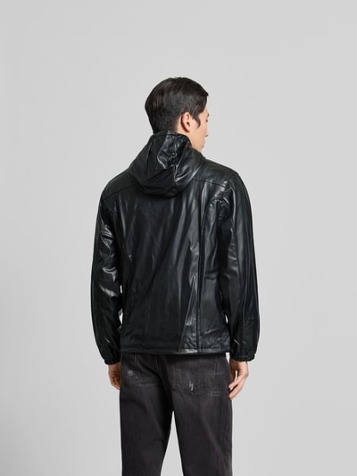 Männermodel trägt schwarze Regular Fit Jacke mit Stehkragen von Diesel in Leder-Optik, Ganzkörperansicht Rückansicht.