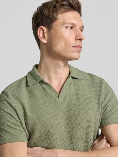 Männermodel trägt Regular Fit Poloshirt aus Baumwoll-Mix von MCNEAL in Waffle-Piqueé, kurzärmelig, Umlegekragen, Nahaufnahme Oberkörper.