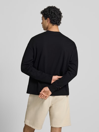 Männermodel trägt Oversized Sweatshirt mit Logo-Stitching Modell 'Rusk' von Pegador aus reiner Baumwolle in Schwarz, Rückenlänge 61 cm, Ganzkörperansicht Rückansicht.