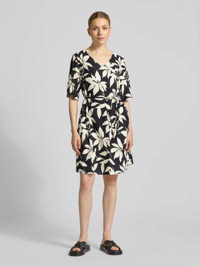 Frauenmodel trägt Relaxed Fix Freizeitkleid aus Viskose-Mix von s.Oliver RED LABEL mit Optik:Allover-Muster, Mini-Länge, V-Ausschnitt, Taillengürtel, Kurzarm, Materialverarbeitung: Crinkle, Ganzkörperansicht von vorne.