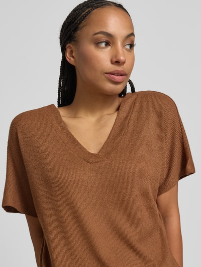 Kobiece model nosi Strickshirt mit V-Ausschnitt Modell 'Delia' od Soyaconcept, mieszanka wiskozy z dodatkiem streczu, krój relaxed fit, długość tyłu 60 cm w rozmiarze S, brązowa faktura, prosty materiał, nahaufnahme górnej części ciała.