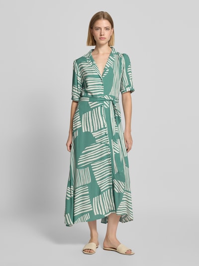 Frauenmodel trägt Midikleid aus reiner Viskose Modell 'Azura' von ZABAIONE in Grün mit weißem Streifenmuster, taillierte Passform, Reverskragen, abnehmbares Taillenband, kurzärmelig, fließende Textur, Ganzkörperansicht von vorne.
