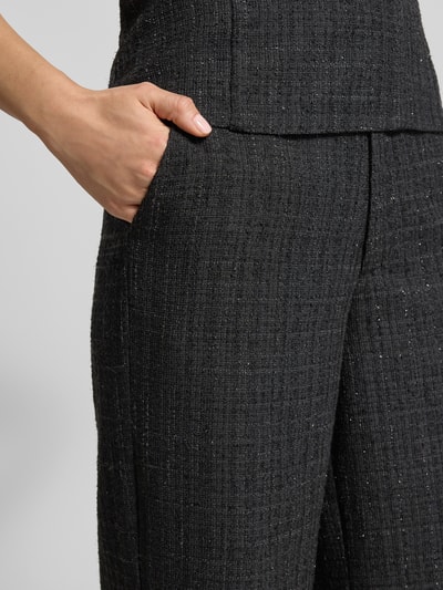 Frauenmodel trägt Stoffhose mit Glitter-Effekt Modell 'Emmett' von Neo Noir, gerader Schnitt, französische Eingrifftaschen, Nahaufnahme Oberkörper.
